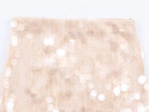 Dettaglio delle paillettes color champagne e della trama in mesh della gonna