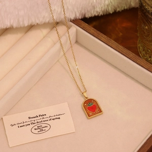 Detail of Sacred Heart pendant with red enamel on gold chain for women