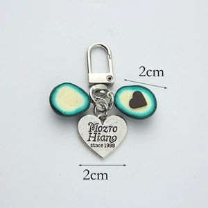 Detail showing creative avocado pendant with heart charm and engraved metal keychain