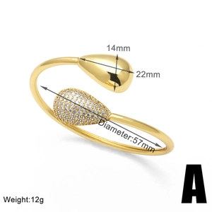 Detail shot of open gold-plated bangle with pear-shaped cubic zirconia and smooth finish