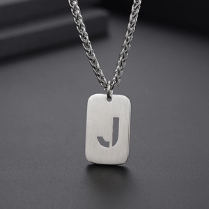 Gros plan sur le pendentif lettre J en argent brossé avec une chaîne torsadée