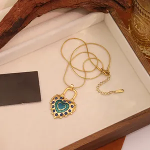 Détail du collier pendentif coeur vintage en acier inoxydable doré sur plateau