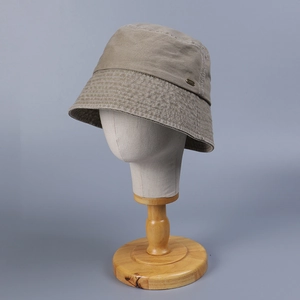Detail of khaki cotton bucket hat featuring multi-row stitching and metal logo plate