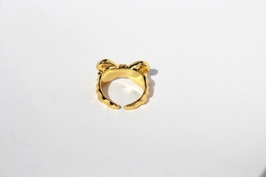 Macro close-up showing the 3D gold bow design and metallic texture of the ring