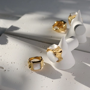 Macro detail of 18K gold-plated ring with square shell inlay and hammered metal texture