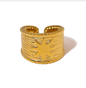 Detailed close-up of a gold adjustable sunburst ring with embossed star and bead texture