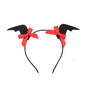 Detail of Halloween bat headband with red silk bow and black wings for party costume