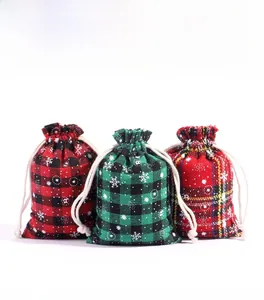 Three Christmas plaid drawstring gift bags featuring white snowflake patterns and thick ropes