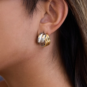 Two-tone 18K gold and silver stainless steel twisted hoop earrings on model