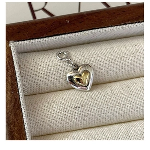 Macro shot of two-tone S925 silver and gold heart pendant in a luxury jewelry box