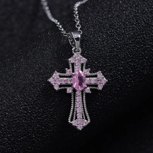Detailed macro view of punk cross pendant with pink gemstones and silver alloy base
