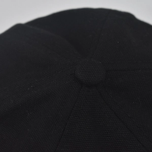 Makroansicht der Baumwolltwill-Textur und der Nähte an der schwarzen Beanie-Mütze