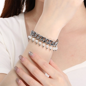 Detailed close-up of a silver Cuban chain bracelet with elegant white pearl pendants