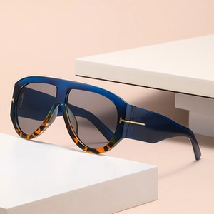 Detail of oval sunglasses with blue frames, tortoiseshell accents and metal T hinge