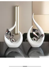 Detail of modern white ceramic and silver metal abstract sculpture on reflective surface