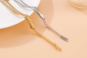 Macro detail of the adjustable stainless steel chain and gold finish clasp on the shell bracelet