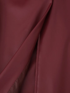 Gros plan sur le cuir PU rouge avec texture grainée litchi et coutures du manteau long