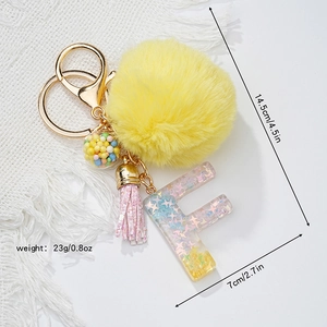 Star resin letter F keychain with yellow faux fur pompom and size dimensions detail