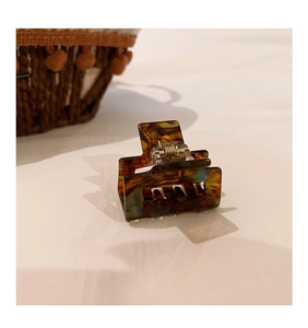 Macro detail of tortoiseshell acetate claw clip showing sturdy metal spring mechanism