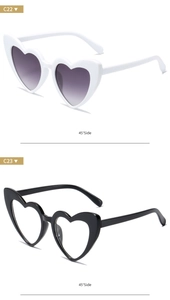 Side view of heart-shaped sunglasses in white and black frames with gradient lenses