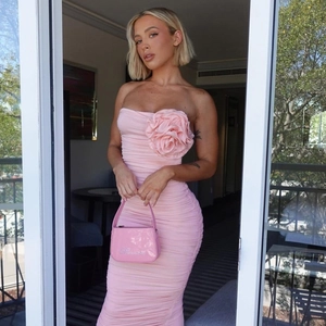 Close-up of pink tube dress featuring a large 3D floral accent and ruched body detail