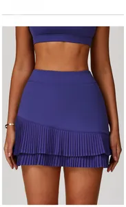 Macro view of high-waisted pleated sports skirt with asymmetric hem in rose blue color