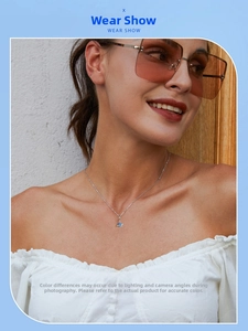 Detail view of the mini planet pendant on a silver necklace worn by a fashion model