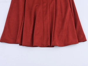 Detailed macro view of the red suede fabric texture and wavy draped hem of the long skirt