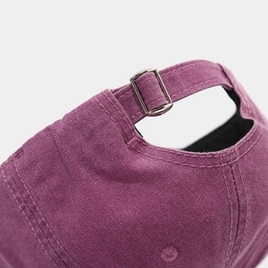 Detailed macro view of the purple cotton baseball cap featuring an adjustable metal buckle