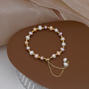Adjustable pearl and gold bead bracelet with white pink and orange freshwater pearls