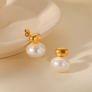 Detailed close-up of French vintage pearl earrings with polished gold metal and white pearl