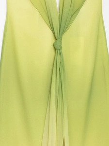 Detail of light green chiffon dress showing deep V-neckline and front knot texture
