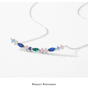 Detailed macro view of silver necklace with curved multicolored pavé-set gemstones