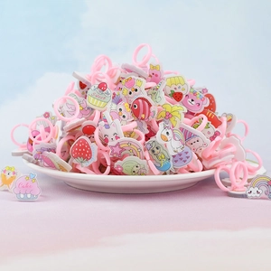 Pile of pink cartoon fruit and cake themed plastic rings for girls on a white plate
