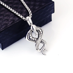 Snake pendant necklace in silver stainless steel on a black jewelry box background