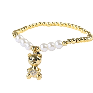 Golden micro-pave bear charm pearl bracelet featuring a crystal heart and metal beads