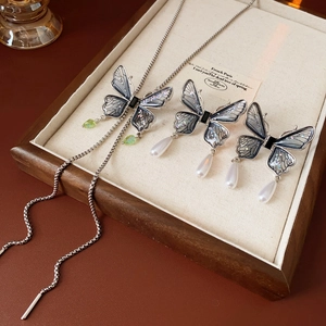 Detail of butterfly necklace and earring set with blue gradient wings and pearls