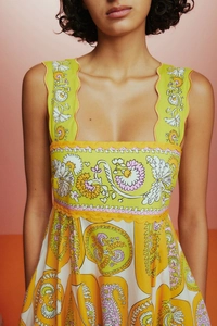 Détail de la robe florale avec encolure carrée et bordures festonnées brodées ondulées