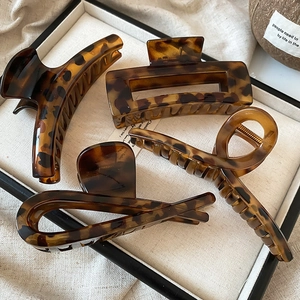 Close-up of four tortoiseshell hair claws in geometric shapes on a display tray