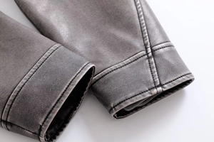 Gros plan sur la manche en similicuir vieilli avec coutures doubles sur veste vintage