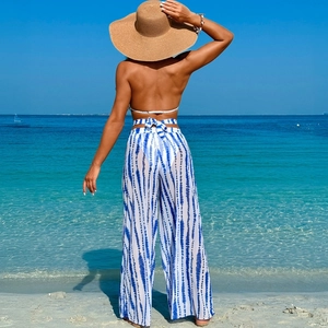 Back view of blue tie-dye bikini set with matching sheer wide-leg pants on beach
