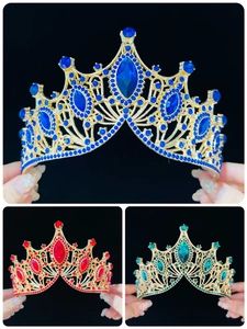 Close-up of baroque bridal crowns in blue, red, and green with crystal details