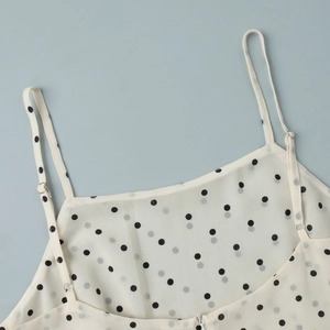 Detail of adjustable thin shoulder straps on white polka dot chiffon camisole top