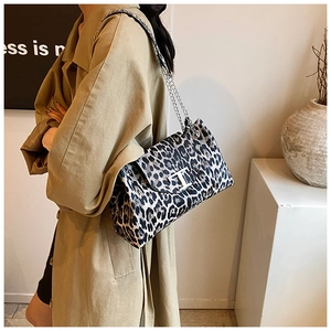 Detailed close-up of leopard print shoulder bag with silver T-buckle and chain strap