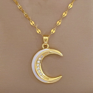 Detailed shot of moon pendant with enamel inlay and pavé crystals on leaf-shaped chain