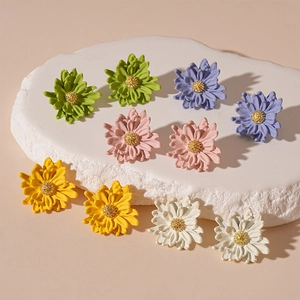 Chic daisy flower stud earrings in five pastel colors on a white stone display