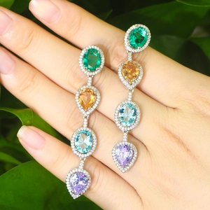 Elegant multi-color gemstone drop earrings with crystals on a natural green leaf background
