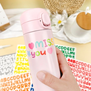 Detailed view of DIY alphabet stickers on pink stainless steel thermos with floral decor