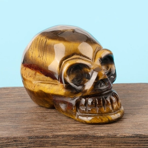Detailed close-up of a hand-carved tiger eye stone skull with natural golden brown texture