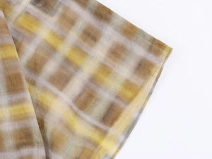 Detailaufnahme des gelb-grauen Karo-Schals aus atmungsaktivem Seidengewebe mit Textur